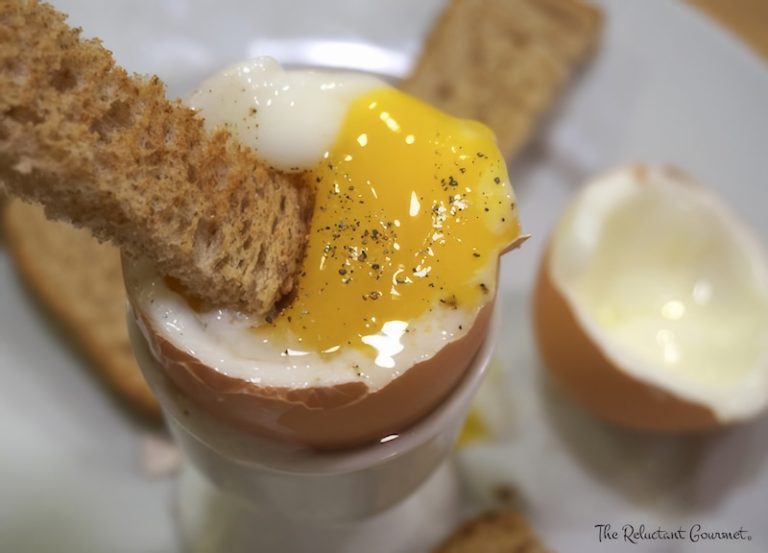 A soft boiled egg in an egg cup with a toast soldier.