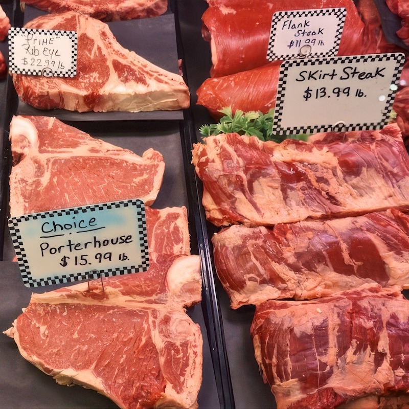 A butcher's counter filled with various steak cuts.